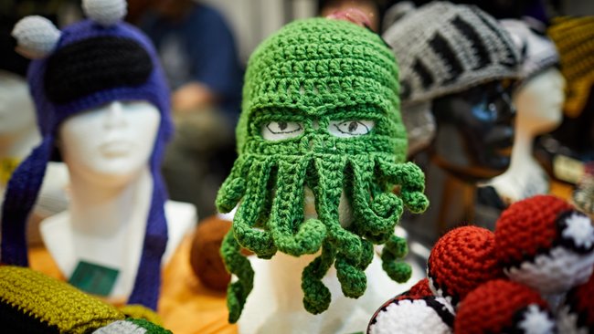 Gezeigt wird gestrickte Spiele-Merchandise wie eine Oktopus-Maske. 