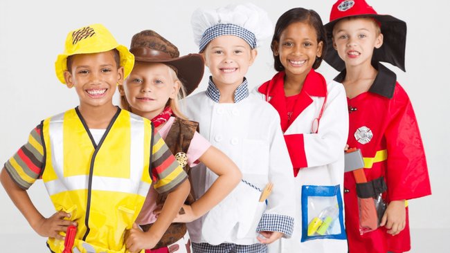 Gezeigt werden fünf Kinder, die als Handwerker, Cowboy, Koch, Ärztin und Feuerwehrmann verkleidet sind.