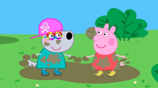 Gezeigt wird ein Screenshot aus dem Videospiel "Meine Freundin Peppa Pig", auf dem Peppa und eine Hundespielfigur in einer Pfütze auf einer Wiese stehen und mit Schlamm beschmutzt sind.