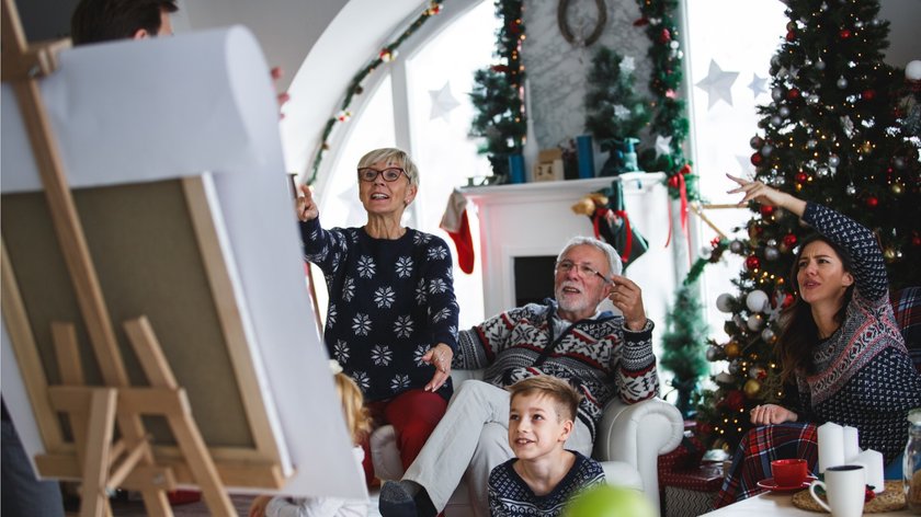 Gezeigt wird eine Familie mit drei Generationen, die gezeichnete Scharade spielt.