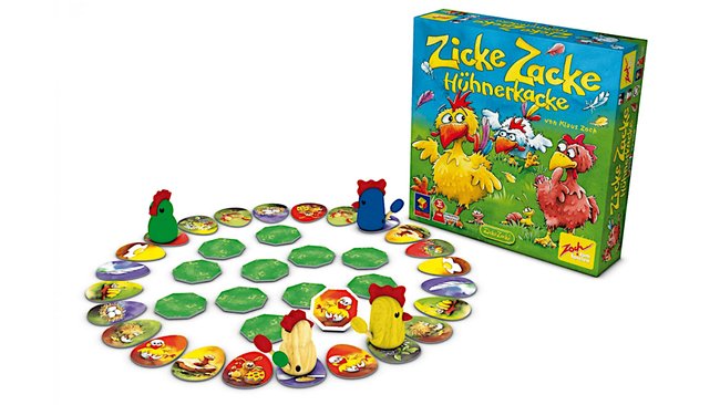 Das Bild zeigt das Brettspiel "Zicke Zacke Hühnerkacke" von Zoch. Im Vordergrund ist das Spielbrett zu sehen, das aus bunten, runden Plättchen mit verschiedenen Motiven besteht, die im Kreis angeordnet sind. Auf dem Spielfeld befinden sich bunte Hühnerfiguren aus Holz. Im Hintergrund ist die Spielverpackung zu sehen, die ein farbenfrohes Design mit fröhlichen Hühnern zeigt.