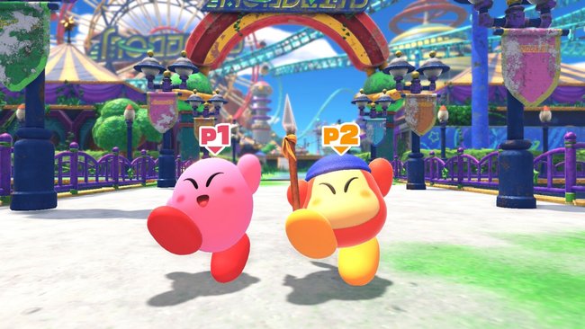 Das Bild zeigt zwei fröhliche Charaktere aus dem Spiel "Kirby und das vergessene Land". Links ist Kirby (P1) in Rosa, rechts ein Waddle Dee (P2) in Gelb mit einem Speer und einer blauen Mütze. Im Hintergrund ist ein bunter Freizeitpark mit einem Torbogen, Lampen und Fahrgeschäften zu sehen.