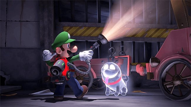 Gezeigt wird eine Szene aus dem Videospiel Luigi's Mansion 3, in dem sich Luigi und ein Geisterhund in einem dunklen Raum befinden und Luigi mit einer Taschenlampe in die rechte obere Ecke leuchtet.