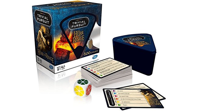 Gezeigt werden die Box, ein Würfel, ein Kartenständer und zwei Kartenstapel aus dem Kartenspiel Trivial Pursuit – Der Herr der Ringe.