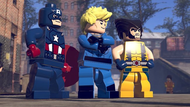 Das Bild zeigt drei LEGO-Superhelden aus einem LEGO Marvel Videospiel. Links steht Captain America in seinem charakteristischen blau-rot-weißen Kostüm mit Stern auf der Brust und seinem Schild. In der Mitte befindet sich eine Figur mit blondem Haar in blauer Uniform. Rechts steht Wolverine in seinem ikonischen gelben Kostüm mit blauen Handschuhen und seiner typischen schwarzen Frisur. Die drei Figuren stehen nebeneinander in einer städtischen Umgebung mit Ziegelgebäuden und Bäumen im Hintergrund. Die Grafik ist im typischen LEGO-Videospiel-Stil mit den charakteristischen LEGO-Minifiguren dargestellt.