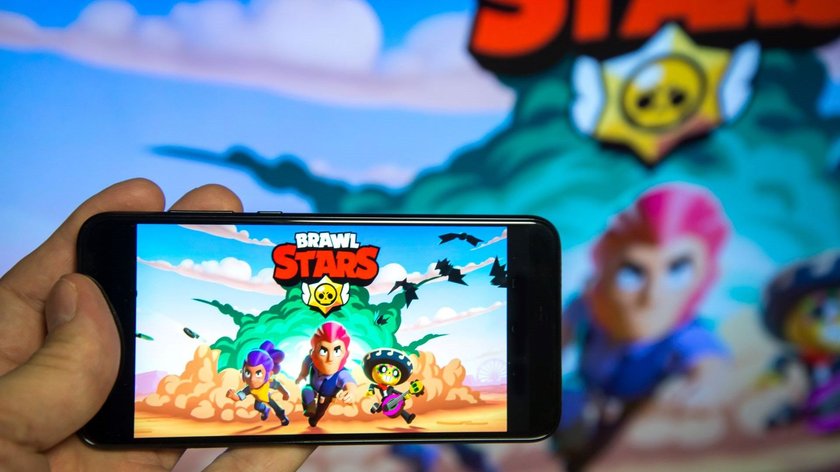 Eine Hand hält ein Smartphone, das den Startbildschirm der Spiele-App Brawl Stars zeigt.